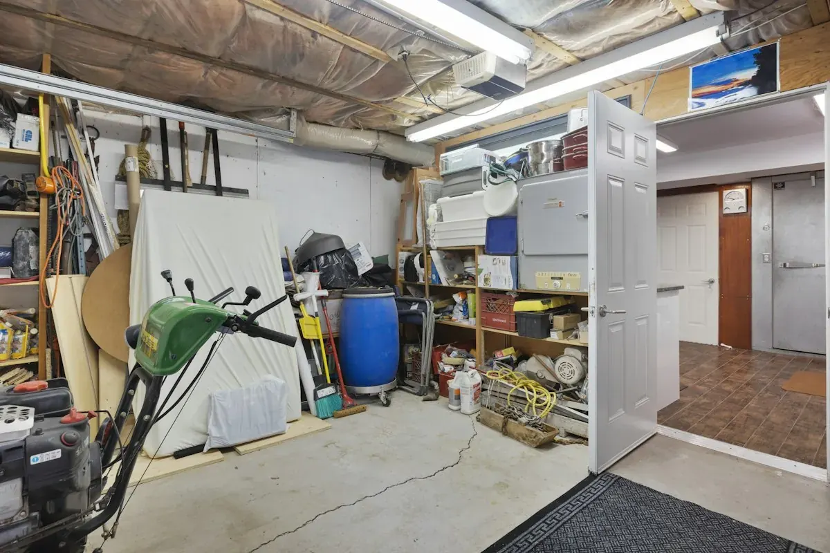 A cluttered garage with open shelving and no cabinets, the starting point for garage storage in Mobile AL