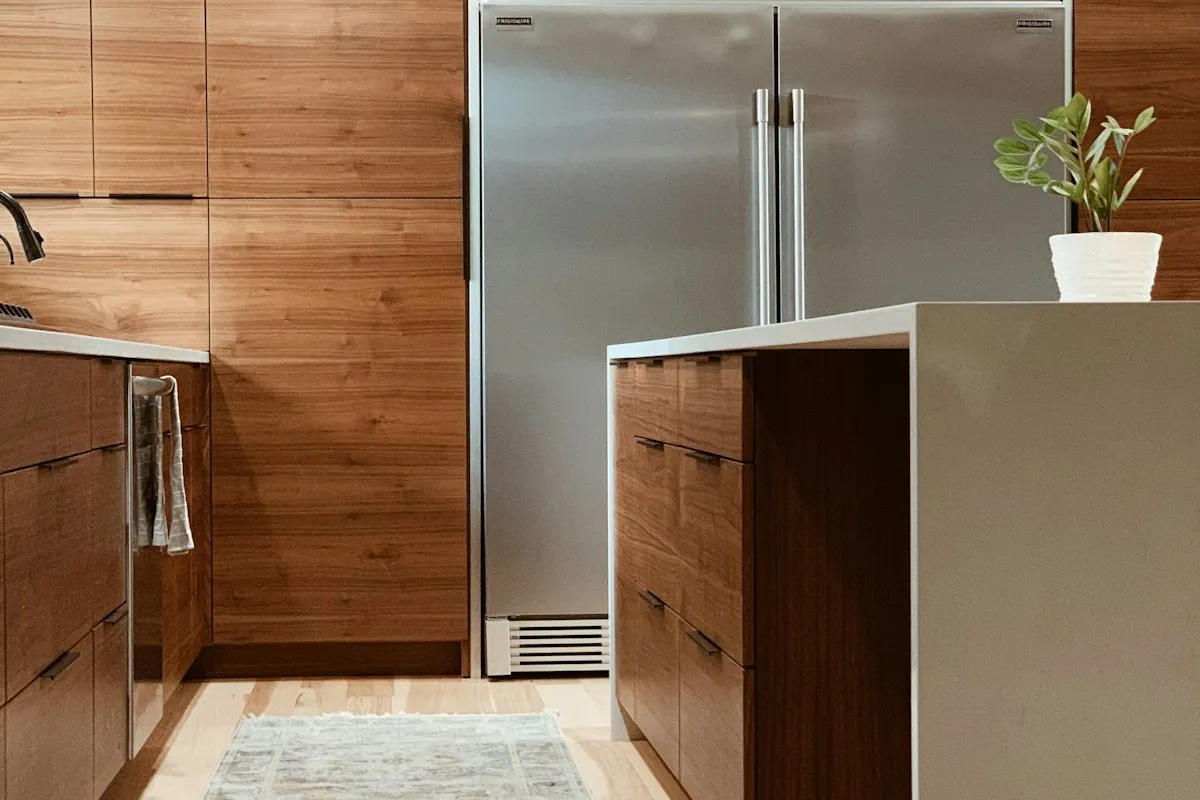 Flat slab walnut cabinet doors with black bar pulls in a Mobile AL kitchen